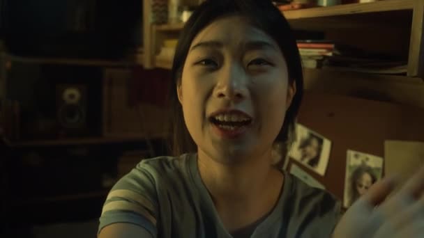 クローズアップUgcセルフィーショット陽気なアジアの女性学生は 友人や家族のためのビデオメッセージを記録し 夕方にマイクロ寮のフラットに座って 良いニュースを共有する — ストック動画