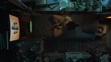 Çinli ya da Koreli bir kızın dağınık bir mikro dairede ranzada oturup TV 'de güzellik reklamı ya da realite şovu izlediği ve akşam evde tek başına dinlendiği bir sahne.