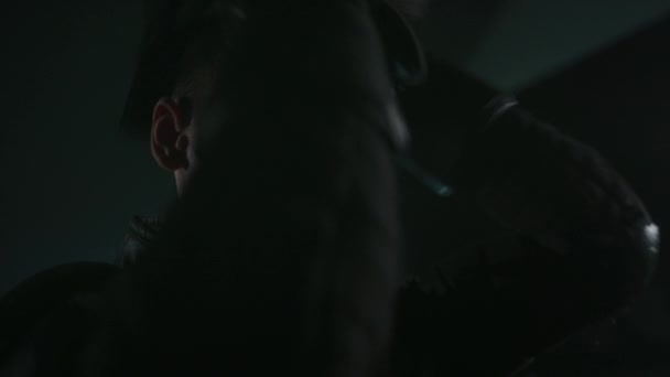 暗いホールで戦う前に黒い金属の網の表面のマスクに置く白人男性のホイルのフェンサーの側面のクローズアップ — ストック動画