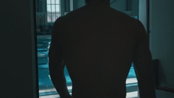 Medium Achterzijde Volgen Schot Van Mannelijke Zwemmer Lopen Uit Kleedkamer — Stockvideo