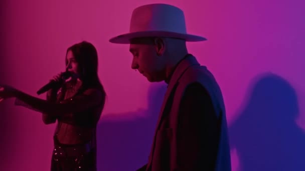 Stüdyoda Pembe Renkli Neon Filtreli Müzik Çalarken Kadın Şarkıcıya Eşlik — Stok video