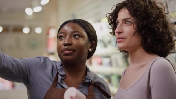 아프리카계 미국인 조수와 코카서스 여성의 얼굴의 클로즈업 상품을 가게에서 제품에 — 비디오