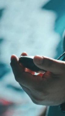 Orta Doğulu eğitmenin el ve yüzünün bokeh etkisiyle yakın çekim kronometredeki durdurma düğmesine basarak, gözlerini kısarak, yarış sonuçlarını duyurarak, havuzda yüzme antrenmanını yöneterek,