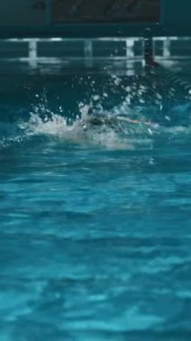 Siyah kauçuk şapkalı anonim sporcunun tam dikey görüntüsü. Gözlükler, şampiyonluk ya da yarışma için antrenman yaparken bilardo şeridi ayracı boyunca kameraya doğru yüzüyor.