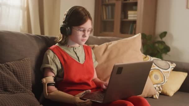 집에서 온라인으로 안경과 헤드폰을 바이오닉 코카서스 홈스쿨러 소녀의 동영상 — 비디오