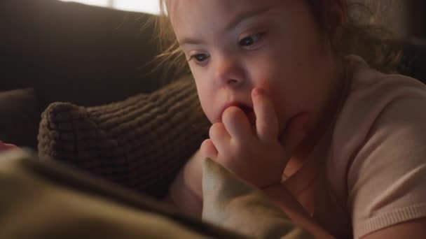 Zbliżenie Bok Ciekawej Białej Dziewczynki Niepełnosprawnością Uważnie Oglądającej Filmy Lub — Wideo stockowe