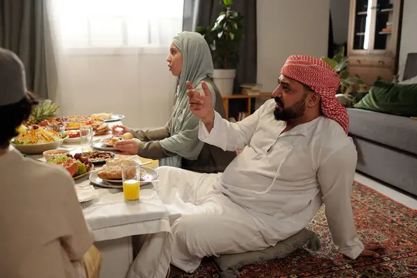 Sakallı Müslüman Adam Kandora Keffiyeh Giyip Şenlik Masasında Oturmuş Aile — Stok fotoğraf