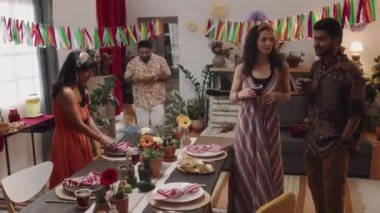 Ev partisinde sohbet eden, Cinco de Mayo kutlayan, kokteyl içen, dans eden, neşeli bir adamın salata getirip herkesi masaya davet ettiği bir grup Meksikalı.