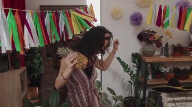 Mutlu, genç Meksikalı bir çiftin ananas, tekila şişesi taşıyarak tatillerini kutlamak için eve gelişinin orta boy görüntülerini izliyoruz.