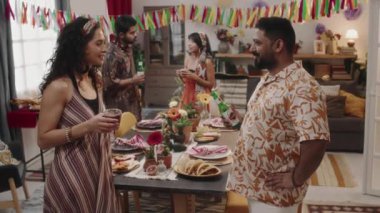 Genç Meksikalı ya da İspanyol kadın ve parlak elbiseli bir adamın neşeli bir akşam yemeği için hazırlanıp, sohbet edip, haberleri tartıştıktan sonra kokteyl ve bira eşliğinde kadeh kaldırdığı orta boy görüntüler.