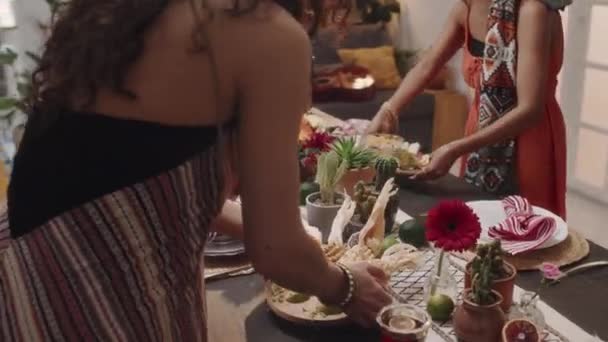 2つの匿名のメキシコ人またはヒスパニック女性の手のショット ローストトウモロコシ タコス サルサ グアカモレをテーブルに置いて祝宴 祝日や家族のイベントを祝う — ストック動画
