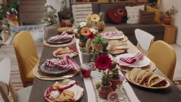 クローズアップダイナミックな人々は 洗練された伝統的なメキシコ料理やスナック パーティーの準備ができてディナーテーブルを撮影しません ナチョス タコス シャルパ サルサ サラダ 花で装飾 サラダ — ストック動画