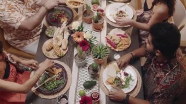 Orta boy iki Meksikalı genç çiftin festival masasında oturup Cinco de Mayo 'yu kutlarken, lezzetli geleneksel yemekler yerken, koca bir tabak Chalupa' yı uzatırken, karısı da bir tane yerken.