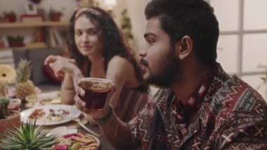 Orta boy Meksikalı bir çift parti ziyafetinde otururken Cinco de Mayo 'yu arkadaşlarıyla kutluyorlar. Koca kokteyl tutuyor ve diğer konuklarla konuşuyor. Karısı ona bakıyor ve dinliyor.