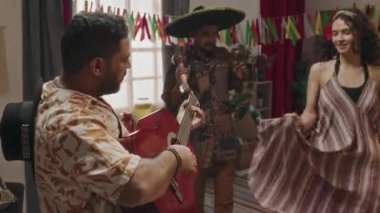 Sombrero şapkalı iki Meksikalı adamın marakas gitarlı geleneksel şarkısını çalarken çekilmiş orta boy görüntüler. Ve güzel, genç bir kadının saçlarıyla dans edip kıvrılırken görüntüsü.