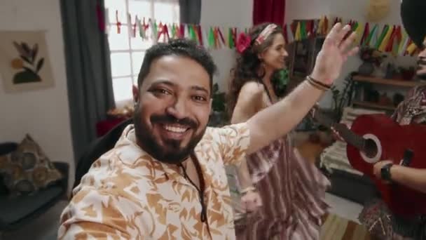 ミディアムUgcセルフィーショット 陽気なメキシコ人の男がスマートフォンを持ち出し 自宅パーティーで楽しんだ自分や友人を撮影し ソンブレロでギターを弾く男 女が踊って音楽に泳ぎます — ストック動画
