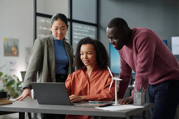 Group Young Successful Intercultural Employees Looking Laptop Screen While Discussing Royalty Free Stock Photos
