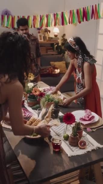 两名年轻的墨西哥人或拉美裔妇女将烤玉米 墨西哥玉米片 意大利面 意大利面和墨西哥面放在桌上供家人共进晚餐以庆祝国庆节 以及聊天的中式垂直镜头 — 图库视频影像