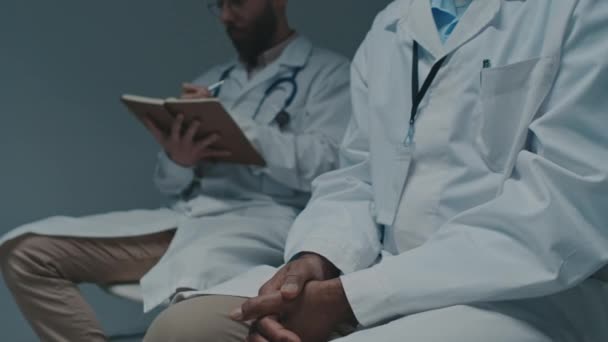 Середній Знімок Двох Різноманітних Лікарів Чоловіків Білих Халатах Сидять Медичній — стокове відео