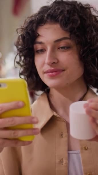 Kafkasyalı Genç Bir Kadının Elinde Krema Kavanozu Olan Akıllı Telefon — Stok video