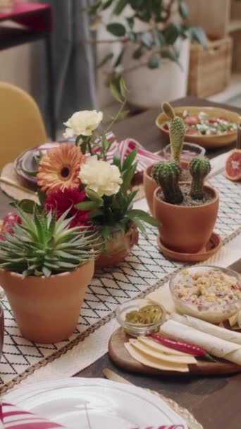 クローズアップ垂直の人々は 伝統的なメキシコ料理を食欲をそそるテーブルを撮影しませんでした セッティで装飾 ジェルベラの花 ペヨーテ 国民の祝日を祝う準備ができています — ストック動画