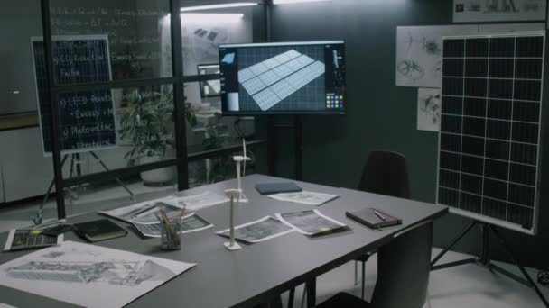 现代可再生能源部门办公室内部没有配备多媒体屏幕 太阳能电池板模型 风车原型以及桌子和墙壁上的多张蓝图的人镜头 — 图库视频影像