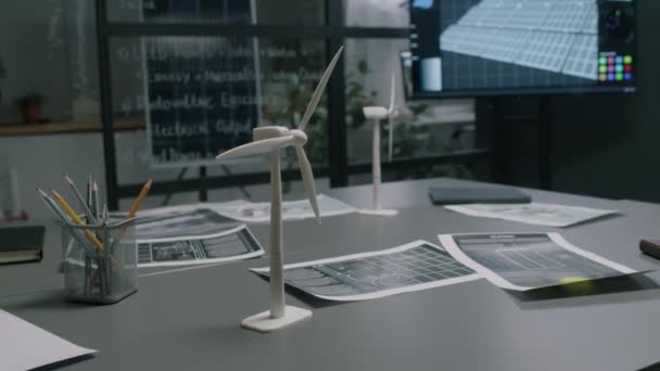 在配备多媒体屏幕和玻璃墙的现代替代能源部门办公室里 没有人看到有接近多份文件的风车原型桌子的镜头 — 图库视频影像