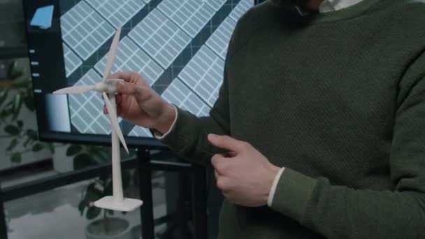 強化された風車のプロトタイプを保持し ビジネスミーティング中にパートナーにその特性と利点を提示するメガネの男性ひげ付きエンジニアの側面傾斜映像 — ストック動画