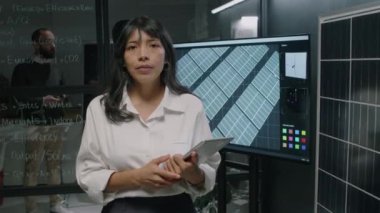 Alternatif Enerji Bölümü 'nde iş günü kameraya bakıp tabletle poz veren İspanyol kadın mühendisin portresini çıkar.