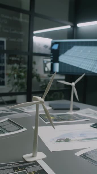 マルチメディア スクリーンが付いている再生可能エネルギー部門のオフィスの複数の青写真および文書の近くのテーブルの風力タービン モデルの縦の映像無し — ストック動画