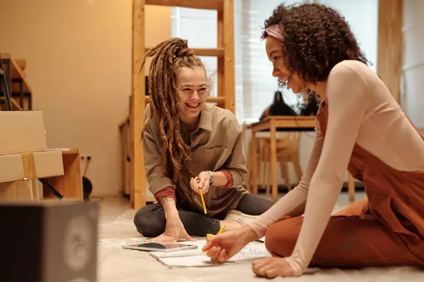 Two Young Laughing Women Casualwear Sitting Floor Cafe Unfinished Renovation Stock Photo