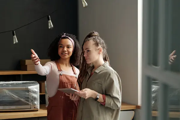 Young African American Woman Overalls Showing Interior Cafe Female Colleague Stock Image