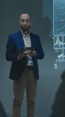 Erkek ilaç satış temsilcisinin konferansta doktorlara yeni ilaç ya da terapi sunan tabletle tam dikey görüntüleri, veri grafikleri gösterilmesi, faydalardan bahsedilmesi