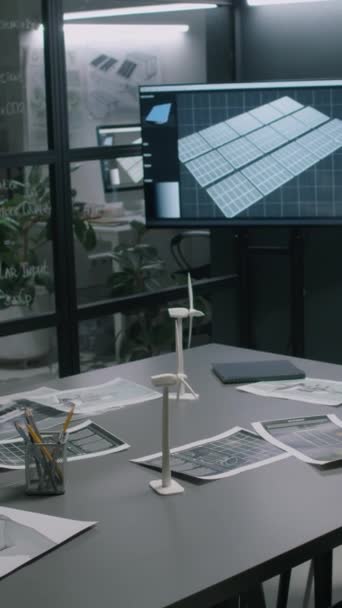 マルチメディアスクリーン ウィンドミルプロトタイプ テーブル上の複数の青写真を備えた現代再生可能エネルギー部門オフィスの内部の垂直映像はありません — ストック動画