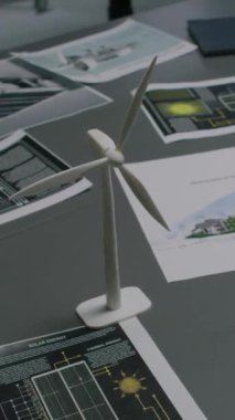 Yeşil Enerji Bölümü 'ndeki modern ofisteki masada insanların dikey yüksek açılı görüntüleri, dokümanlar ve rüzgar türbini modeli yok.