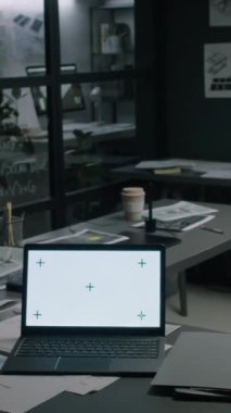 İnsanların dikey görüntüsü yok. Boş alternatif enerji departmanı ofisinin çoklu planları ve çizimleri var. Masasında kromakey ekranı olan dizüstü bilgisayar.