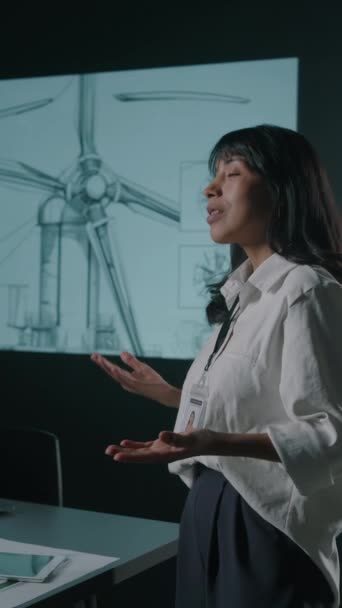 パートナーに新しい風力タービンローターブレードを実証し 会議で青写真を指摘する女性ヒスパニックイノベーターの垂直映像 — ストック動画