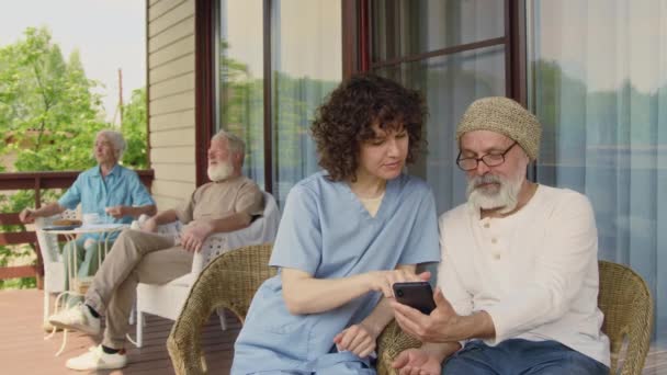 Средний Снимок Улыбающейся Белой Женщины Пенсионерки Пожилого Мужчины Сидящего Вместе — стоковое видео