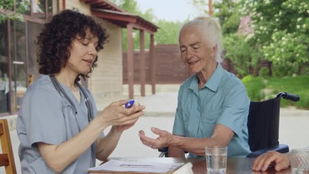 Medi Filmati Giovane Infermiera Uniforme Chatta Con Anziani Signora Caucasica — Video Stock