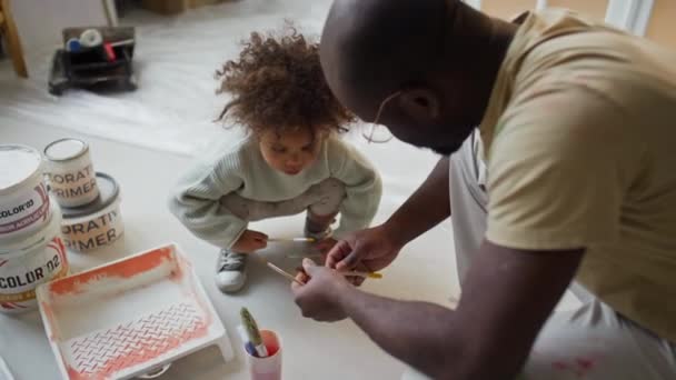 高角镜头的非裔美国父亲向女儿解释装修房间时用什么刷子 女孩帮助爸爸 — 图库视频影像