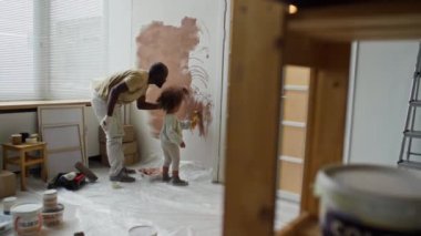Küçük kızıyla birlikte duvarları kahverengiye boyarken bekar bir babanın çocuk odasını yeniden dekore edişinin tam görüntüleri.