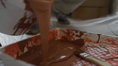 Boya yapmadan önce boyacının tepsiye kahverengi boya döktüğü yakın plan.