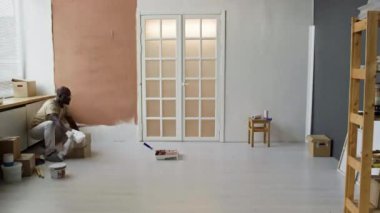 Oda yenileme işlemi sırasında çeşitli çiftlerin tam zaman aralığı, yere polietilen yayıyorlar ve merdivenle duvarları kahverengi boyayla boyuyorlar.
