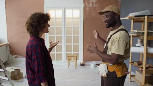 关于有信心的黑人杂工谈论房间整修计划 和白人公寓的女士做交易 握手的侧面镜头 — 图库视频影像