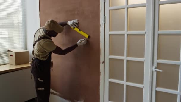 Siyah Erkek Müteahhitin Oda Tadilatı Sırasında Ölçü Aletini Kullanarak Duvarda — Stok video