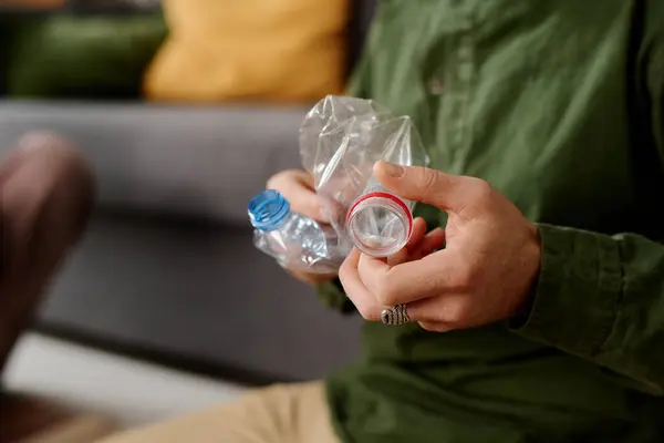 Руки Неузнаваемого Человека Скручивающего Разбивающего Пустые Пластиковые Бутылки Сидя Перед Стоковое Изображение