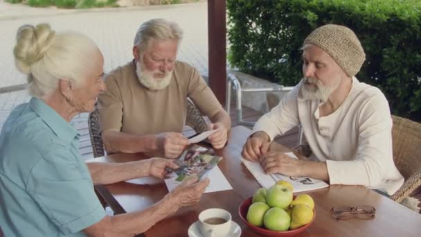 Medium Shot Van Drie Bejaarden Die Buiten Aan Tafel Zitten — Stockvideo