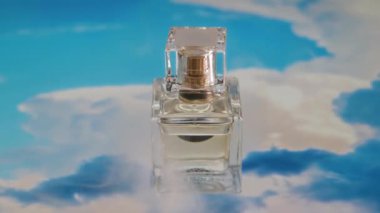 Hiç kimse soyut parlak gökyüzü arka planında dumanlı şeffaf cam parfüm ya da parfüm şişesine yakından bakmaz.
