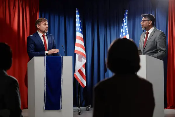2人の異文化的な成熟した男性政治家がトリプルーンに立って 特別な操作の瞬間の議論の中でお互いを見ています ストック写真