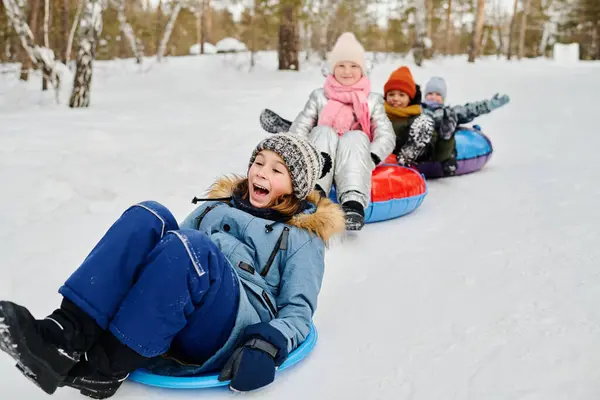 Cute Excited Boy Winterwear Sitting Slide While Moving Snow Hill Royalty Free Stock Images